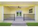 Covered porch featuring elegant railings and double doors that open to a beautiful view at 975 Cr 542E, Bushnell, FL 33513