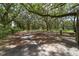 Gated property entrance featuring mature trees providing privacy and a sense of seclusion at 975 Cr 542E, Bushnell, FL 33513