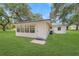 Charming rear exterior of home with green roof, grass, and ample natural light through the windows at 975 Cr 542E, Bushnell, FL 33513