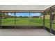 Spacious screened-in porch with views of the vast, green yard and surrounding trees and outbuildings at 975 Cr 542E, Bushnell, FL 33513