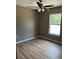 Cozy bedroom featuring neutral colors, wood-look floors, and a ceiling fan for added comfort at 10375 Se 126Th Ln, Belleview, FL 34420