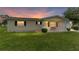 Charming single-story home featuring a cozy front porch and well-maintained lawn at sunset at 10720 Sw 63Rd Ave, Ocala, FL 34476