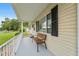 Inviting front porch with a cozy bench and a view of the well-kept front yard at 10720 Sw 63Rd Ave, Ocala, FL 34476