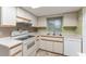 Charming kitchen featuring white cabinets, tile flooring, and updated appliances for a functional cooking space at 10720 Sw 63Rd Ave, Ocala, FL 34476