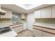 Bright kitchen with skylight, features neutral cabinets, sink with a window, and a white door at 10720 Sw 63Rd Ave, Ocala, FL 34476