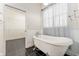 Bathroom with freestanding tub, black tile, and walk in closet access at 10835 Se Highway 464C, Ocklawaha, FL 32179