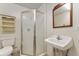 This bathroom features a stand up shower, vanity sink, toilet and a mirror; a storage cabinet is installed at 10835 Se Highway 464C, Ocklawaha, FL 32179