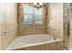 Close up of a bathroom featuring a soaking tub with a shower, framed mirror, vanity, and a tiled floor at 10835 Se Highway 464C, Ocklawaha, FL 32179