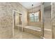 Bathroom showcases a soaking tub with tile surround, a shower, and a mirrored closet at 10835 Se Highway 464C, Ocklawaha, FL 32179
