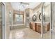 Elegant bathroom with double vanities, soaking tub, walk-in shower, and decorative tile accents at 10835 Se Highway 464C, Ocklawaha, FL 32179