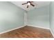 Minimal bedroom featuring light green walls, wood flooring, ceiling fan, and a window at 10835 Se Highway 464C, Ocklawaha, FL 32179