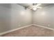 This is an empty bedroom with neutral walls, carpet and white trim; a ceiling fan is installed for comfort at 10835 Se Highway 464C, Ocklawaha, FL 32179
