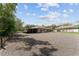 Large gravel parking area for the house, offering convenient space and access to various buildings at 10835 Se Highway 464C, Ocklawaha, FL 32179