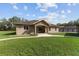 A well-kept lawn enhances this home's curb appeal, featuring stone accents and inviting front entry at 10835 Se Highway 464C, Ocklawaha, FL 32179