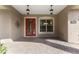 Front entry showcasing a red front door with glass detailing and a covered porch area at 10835 Se Highway 464C, Ocklawaha, FL 32179