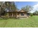 Charming home with stone accents, large arched window, covered porch, and lush green lawn at 10835 Se Highway 464C, Ocklawaha, FL 32179