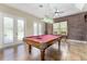Game room featuring a red pool table, exposed brick accent wall, and natural light at 10835 Se Highway 464C, Ocklawaha, FL 32179