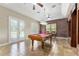 Spacious game room with a pool table, exposed brick, ceiling fans, and double doors leading to outdoor area at 10835 Se Highway 464C, Ocklawaha, FL 32179