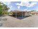 An exterior shot of the garage and covered parking space with pea gravel at 10835 Se Highway 464C, Ocklawaha, FL 32179
