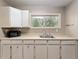 This laundry room features shaker cabinets, a utility sink and a window for natural lighting at 10835 Se Highway 464C, Ocklawaha, FL 32179