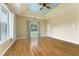Spacious living room with hardwood floors, tray ceiling, neutral paint, and natural light from large windows at 10835 Se Highway 464C, Ocklawaha, FL 32179