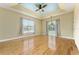 Spacious living room featuring tray ceiling, hardwood floors, large windows, and neutral color palette at 10835 Se Highway 464C, Ocklawaha, FL 32179