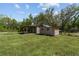 Outdoor shed and covered area on lush green lawn, ideal for storage and projects at 10835 Se Highway 464C, Ocklawaha, FL 32179