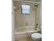 Shower over tub in a bathroom with tiled walls and floral wallpaper border at 1112 Ne 130Th Ter, Silver Springs, FL 34488
