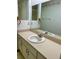 Bathroom featuring a vanity with one sink, ample cabinet space, patterned wallpaper, and large mirror at 1112 Ne 130Th Ter, Silver Springs, FL 34488