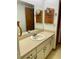 Bathroom featuring a vanity with one sink, ample cabinet space, wallpaper, and large mirror at 1112 Ne 130Th Ter, Silver Springs, FL 34488