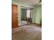 Bedroom featuring carpet floors, mirrored closet doors, and neutral green walls at 1112 Ne 130Th Ter, Silver Springs, FL 34488