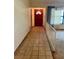 Front entrance features a red front door, tiled flooring, and a view of the adjacent living space at 1112 Ne 130Th Ter, Silver Springs, FL 34488
