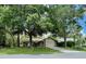Exterior view of the house with mature trees, a well-kept lawn, and an attached garage at 1112 Ne 130Th Ter, Silver Springs, FL 34488