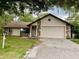 Inviting front exterior featuring stone accents, an attached garage, and a neatly maintained lawn at 1112 Ne 130Th Ter, Silver Springs, FL 34488