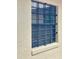 Window secured with metal bars on a stucco wall, ensuring safety and security at 1112 Ne 130Th Ter, Silver Springs, FL 34488