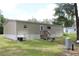 Rear of home with tan siding and back staircase with backyard utilities at 11160 Nw 8Th Ln, Ocala, FL 34482