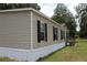 Angled view showcasing the tan siding and black shutters of this single Gathering home at 11160 Nw 8Th Ln, Ocala, FL 34482