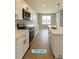 Bright kitchen with white cabinets, modern stainless steel appliances, and wood-look tile flooring at 13145 Sw 78Th Cir, Ocala, FL 34473