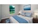Comfortable bedroom featuring a queen-sized bed with stylish blue bedding and ample natural light from the window at 13239 Sw 60Th Avenue Rd, Ocala, FL 34473