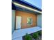 Modern home exterior showing the front entrance with a white door and clean architectural lines and landscaping at 13239 Sw 60Th Avenue Rd, Ocala, FL 34473