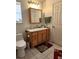 Well-lit bathroom featuring oak vanity with a white countertop and tiled floor at 17051 Ne 243Rd Place Rd, Fort Mc Coy, FL 32134