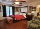 Cozy bedroom featuring a four-poster bed, decorative armchair, and hardwood floors at 17051 Ne 243Rd Place Rd, Fort Mc Coy, FL 32134
