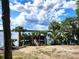 Beautiful lake view featuring a private dock with palm trees and lush greenery at 17051 Ne 243Rd Place Rd, Fort Mc Coy, FL 32134