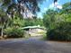 Charming single-story home with a green roof nestled among mature trees and lush landscaping at 17051 Ne 243Rd Place Rd, Fort Mc Coy, FL 32134