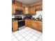 Charming kitchen featuring wood cabinets, stainless steel appliances, and white tiled floors at 17051 Ne 243Rd Place Rd, Fort Mc Coy, FL 32134