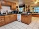Traditional kitchen featuring oak cabinets, green countertops, and white tile floors at 17051 Ne 243Rd Place Rd, Fort Mc Coy, FL 32134