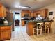 Functional kitchen featuring oak cabinets, a breakfast bar, and tile flooring at 17051 Ne 243Rd Place Rd, Fort Mc Coy, FL 32134