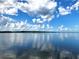 Beautiful view of the calm lake reflecting the blue sky and puffy white clouds at 17051 Ne 243Rd Place Rd, Fort Mc Coy, FL 32134