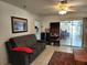 Comfortable living room featuring neutral colors, ceiling fan, and sliding glass doors at 17051 Ne 243Rd Place Rd, Fort Mc Coy, FL 32134