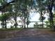 View of the lake with a boathouse, framed by trees and a chain link fence at 17051 Ne 243Rd Place Rd, Fort Mc Coy, FL 32134